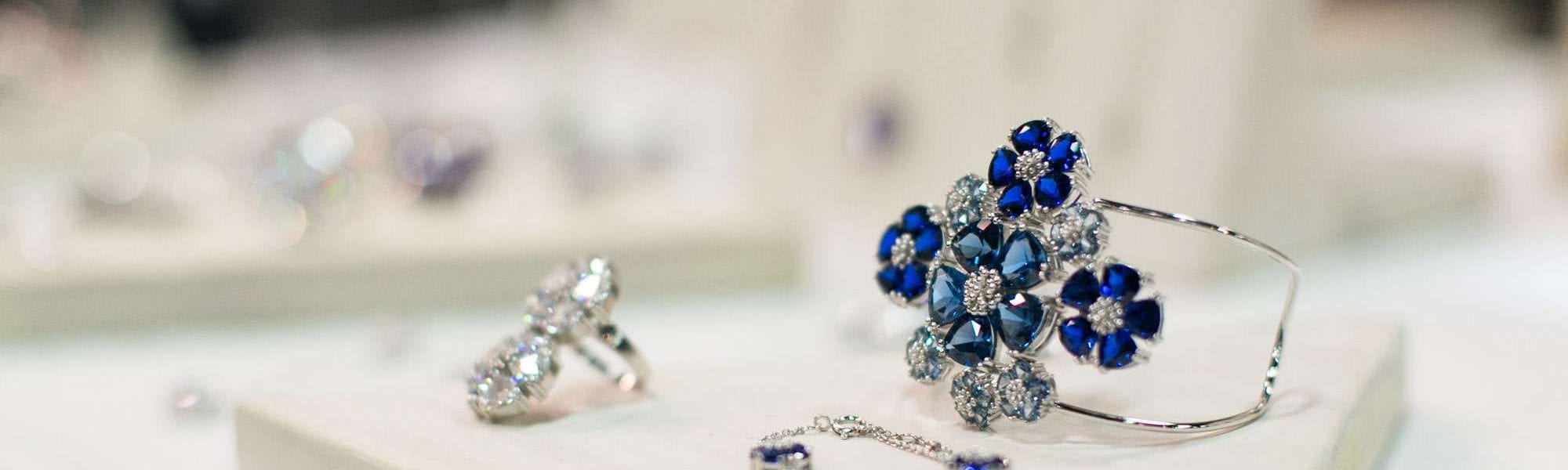 A woman's silver bracelet with blue gemstone flowers