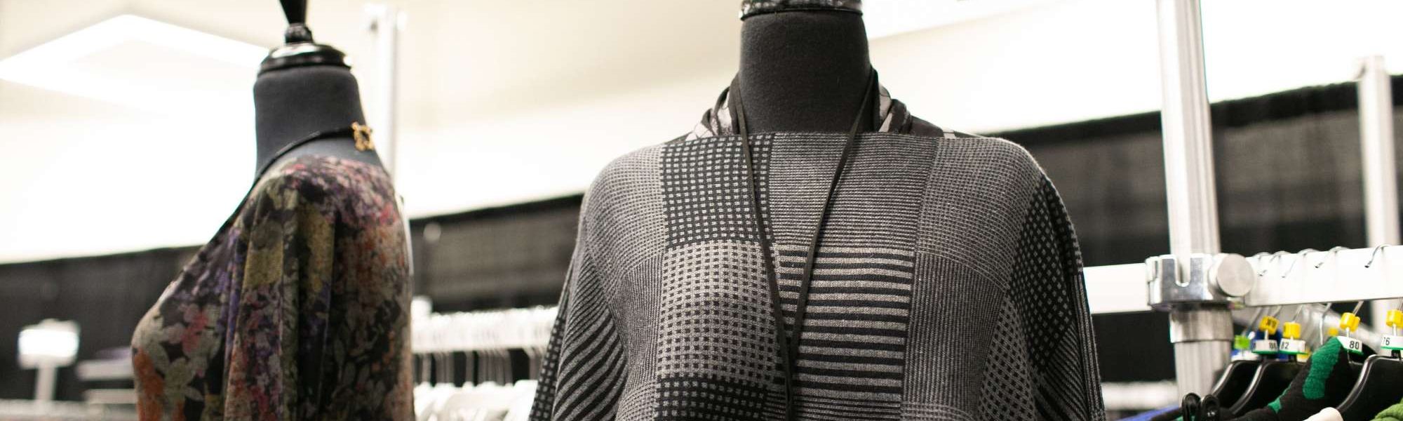 Gray and black outfit on a mannequin with a large silver necklace